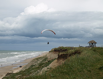Ein Paraglider über dem Strand bei Nr. Lyngby