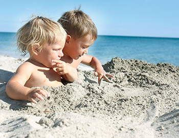 Zwei Kinder spielen im Sand am Strand in Tversted
